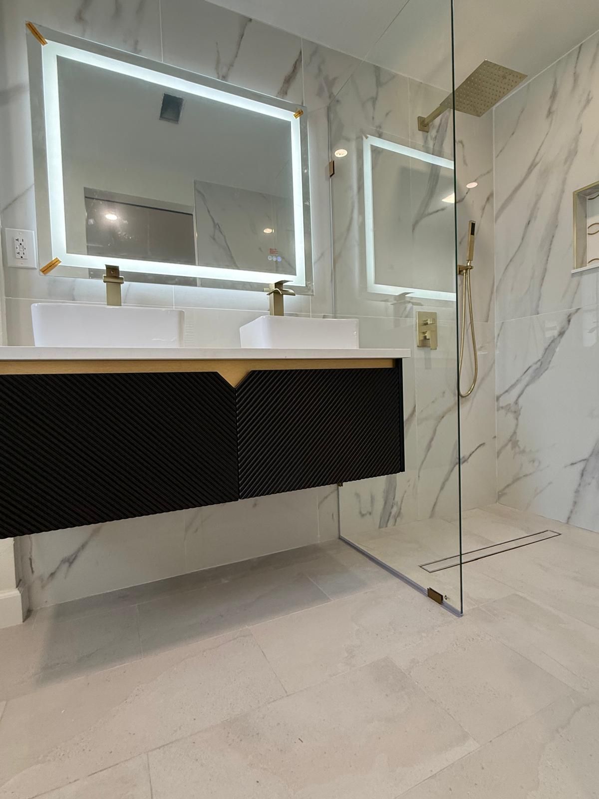 Black floating double vanity with brass accents and LED mirror