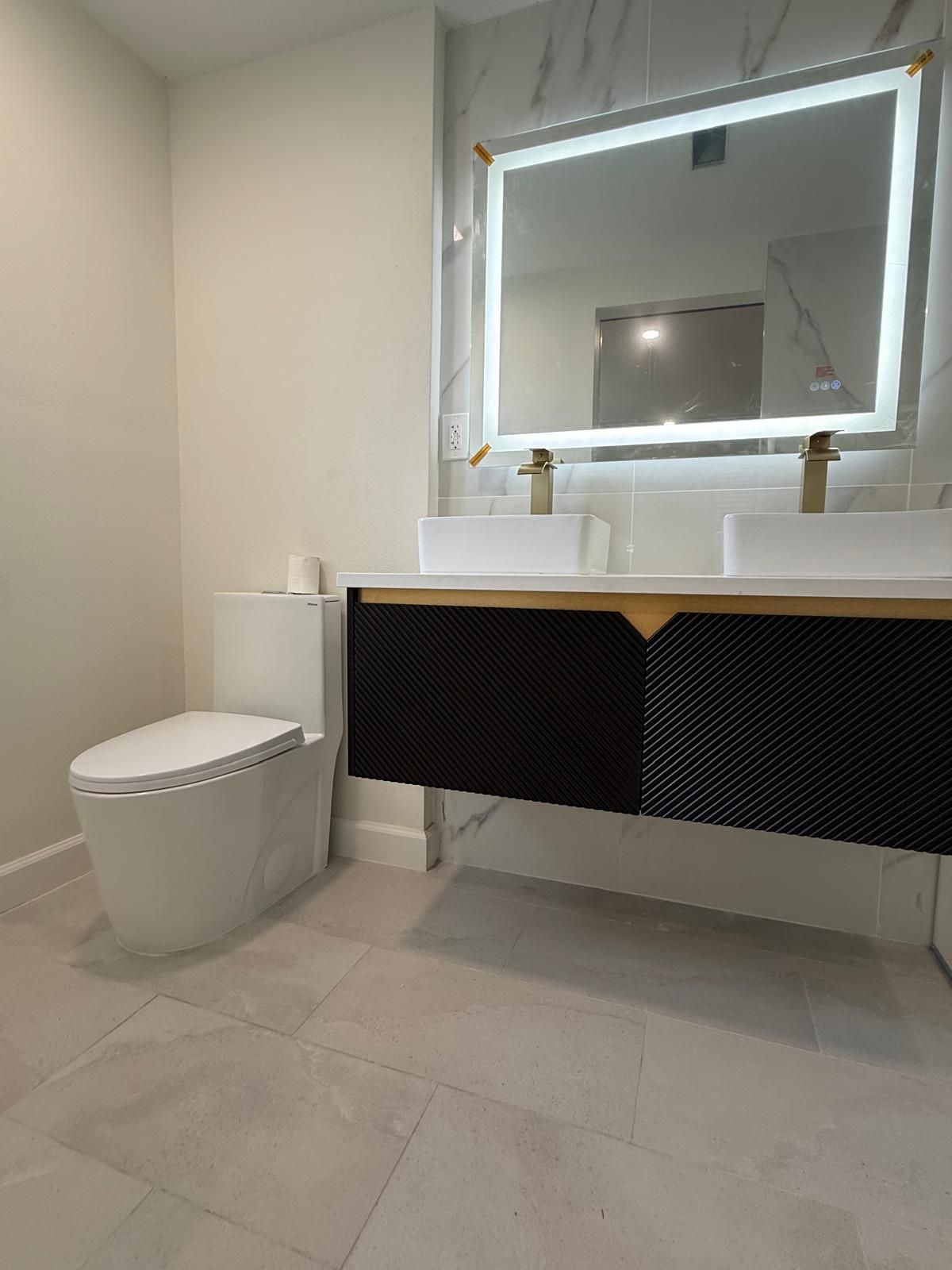 Remodeled bathroom with wall-hung style vanity and one-piece toilet